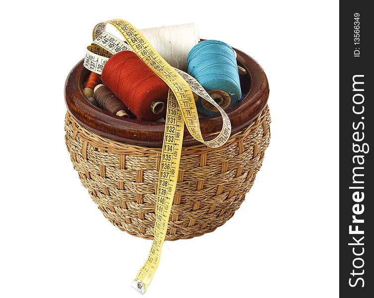 Basket with colour threads and a roulette on a white background. Basket with colour threads and a roulette on a white background