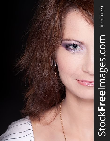 Half portrait of a girl face with makeup against black background