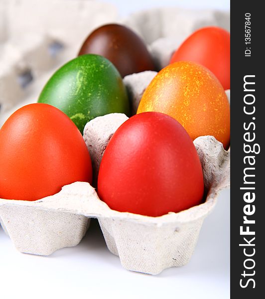 Colorful eggs in a carton
