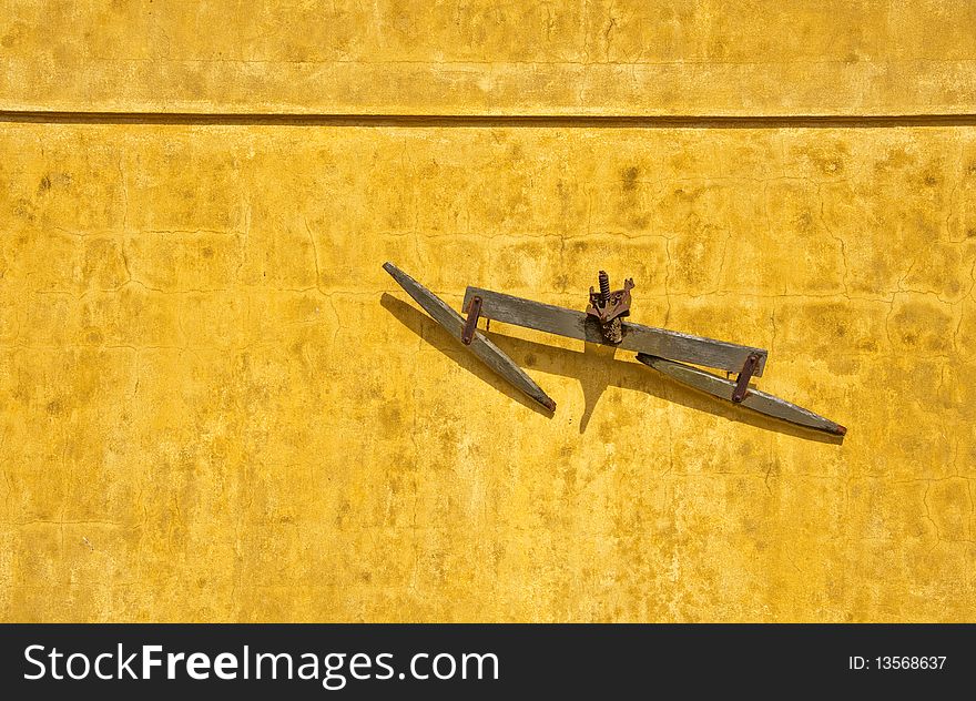 Old bet up and warn out horse plow on a yellow background.