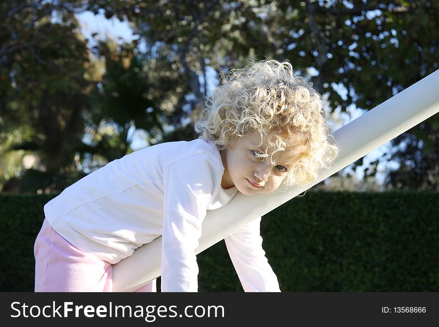 Child hanging from a goal post in a playground. Child hanging from a goal post in a playground