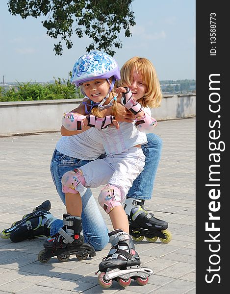 Daughter and mother having fun on in-line skates on a sunny summer day. Daughter and mother having fun on in-line skates on a sunny summer day