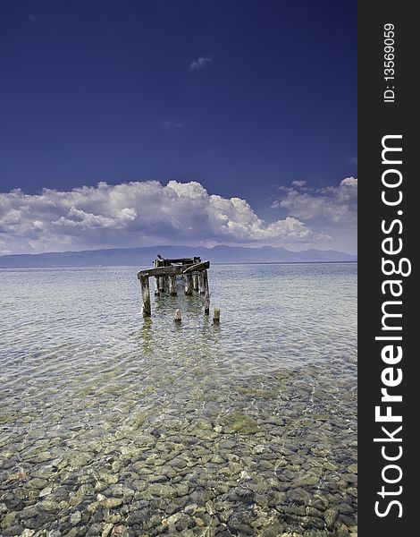 Decayed jetty in a lake blue skies clear water with clear blue sky and cristal clear water