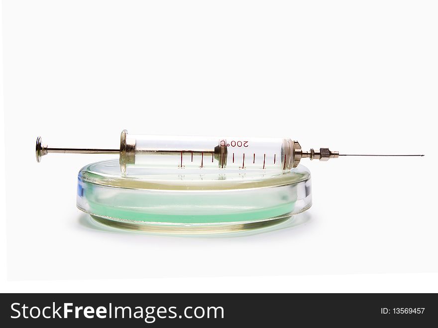 Transparent chemical glassware with green solution with syringe isolated on white. Transparent chemical glassware with green solution with syringe isolated on white