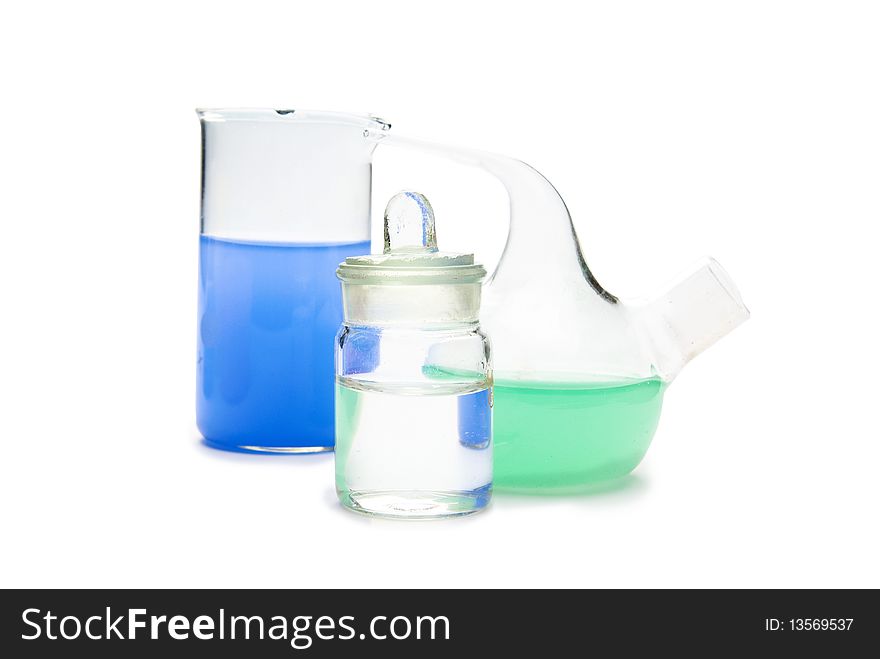 Transparent chemical glassware with green and blue solution isolated on white