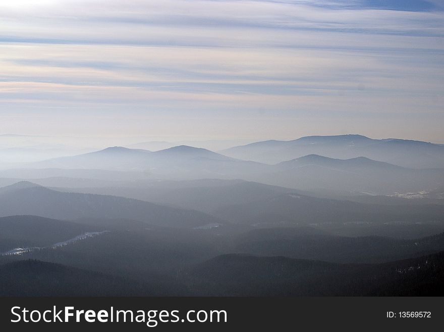 Panoramic snowy mountains in fog and clouds. Panoramic snowy mountains in fog and clouds