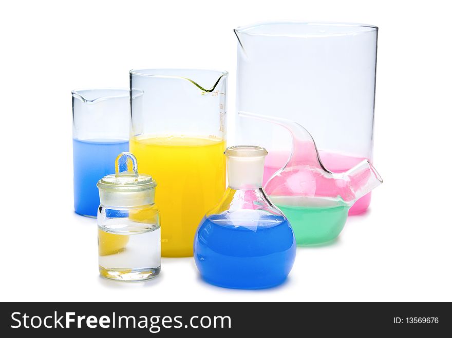 Transparent chemical glassware with red, green, yellow and blue solution isolated on white