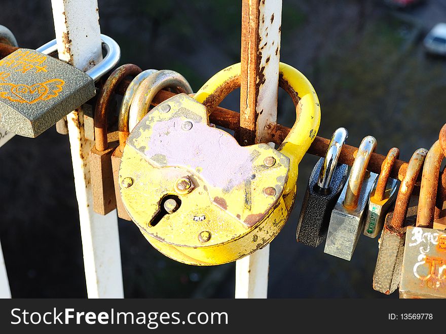 Padlock as a symbol of eternal love on the fortified fence 
 bridge