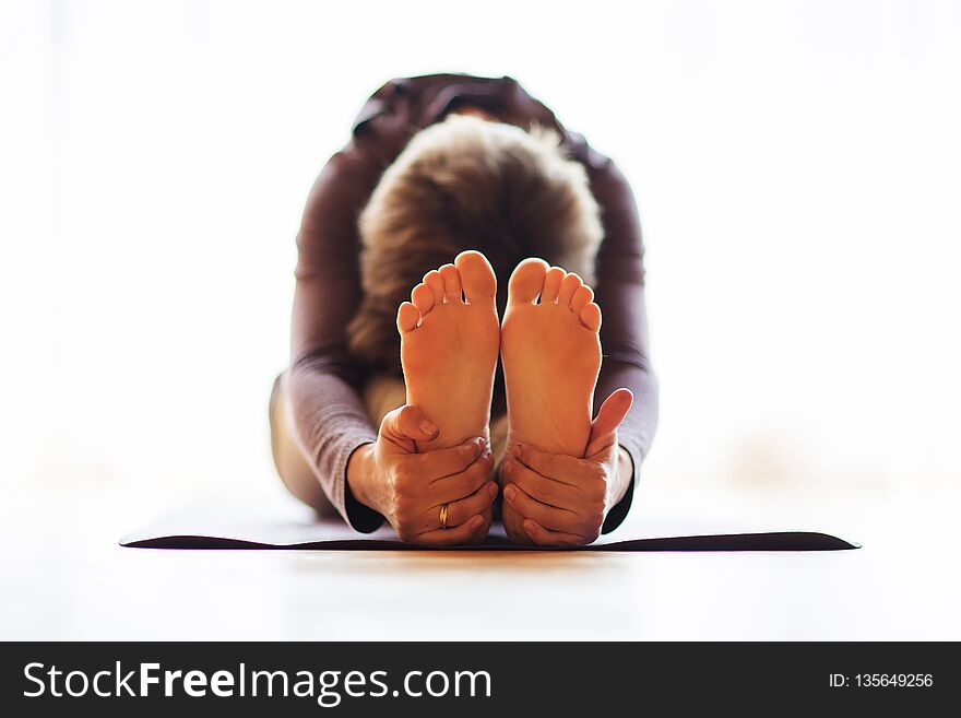 Caucasian Woman Is Practicing Yoga At Studio