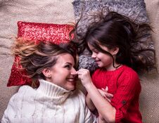 Loving Daughter With Sweaty Hair Is Playing With Her Mother, Lying On The Pillows Care, Comfort, Mother-worn-out, Idyll, Emotions Stock Photography
