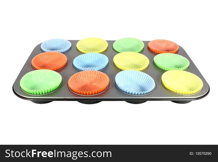 Colorful cups for muffin in a mold isolated on white