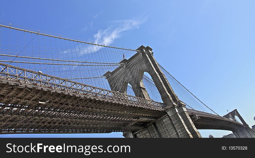 Brooklyn bridge NYC under perfect day light, view from Manhattan's waterfront mini-beach