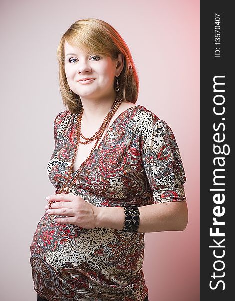 Smiling pregnant woman in pearlbeads. Smiling pregnant woman in pearlbeads