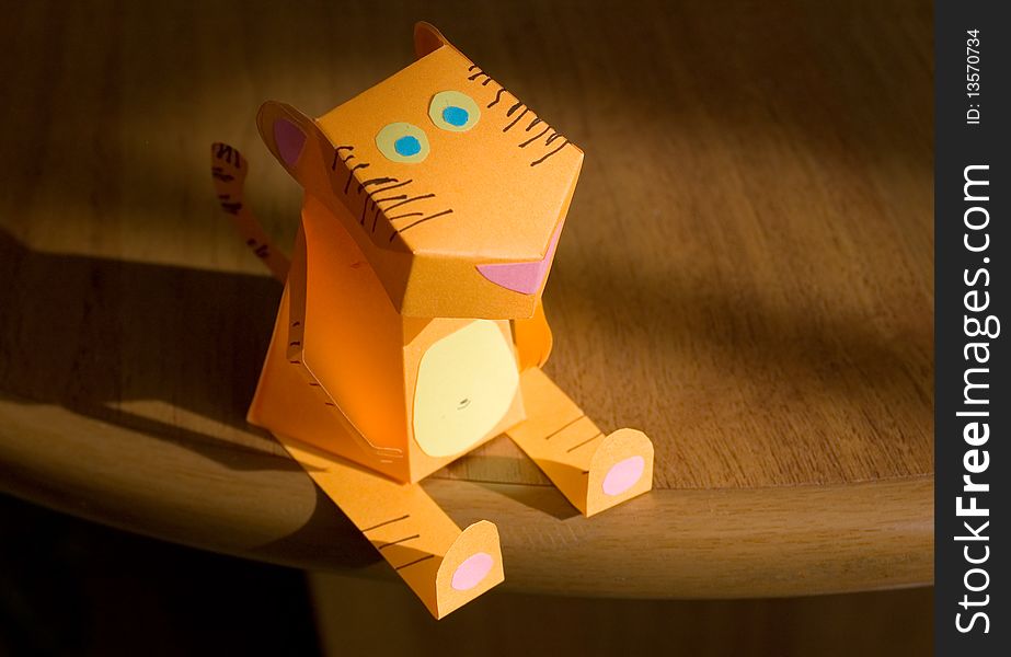 The tiger from an orange paper sits on a table