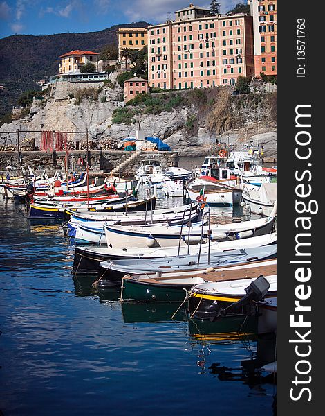 A landscape of a typical village in the Italian Riviera. Here is Camogli between Genoa and Portofino, the boats moored in the port of Camogli reflected in the water. A landscape of a typical village in the Italian Riviera. Here is Camogli between Genoa and Portofino, the boats moored in the port of Camogli reflected in the water.