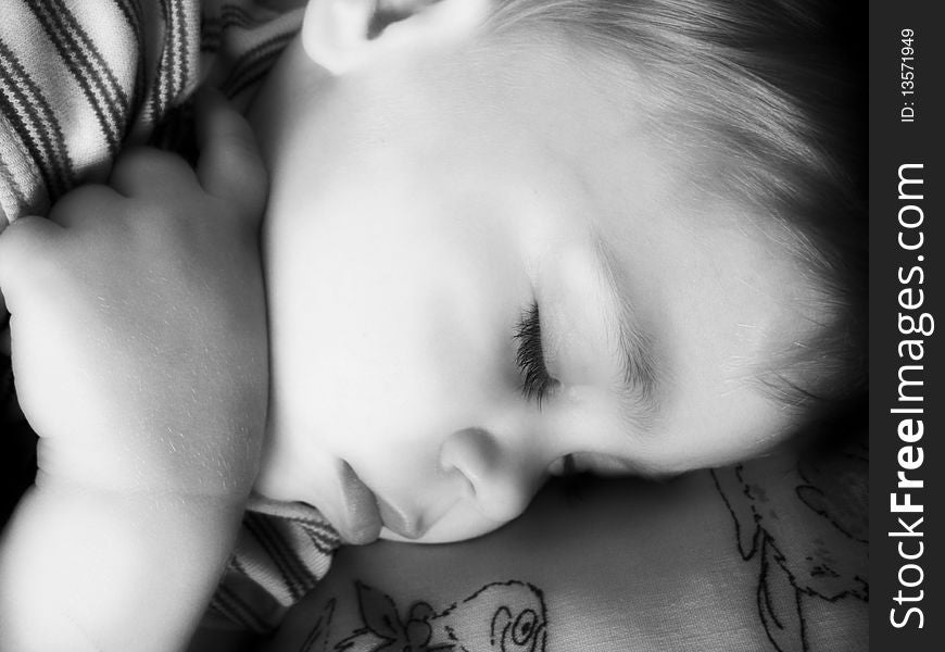 The boy serenely sleeps. Soft focus.Black & white. The boy serenely sleeps. Soft focus.Black & white.