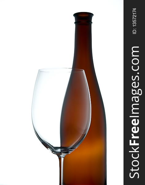 Empty wineglass and brown bottle on a white background. Empty wineglass and brown bottle on a white background