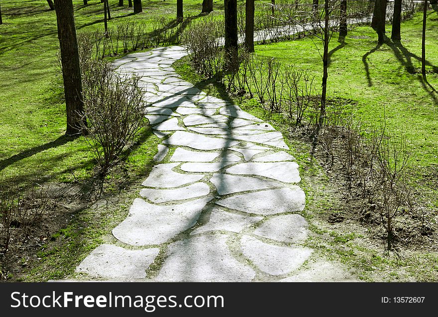 Stone path in the park with tree shadows. Stone path in the park with tree shadows