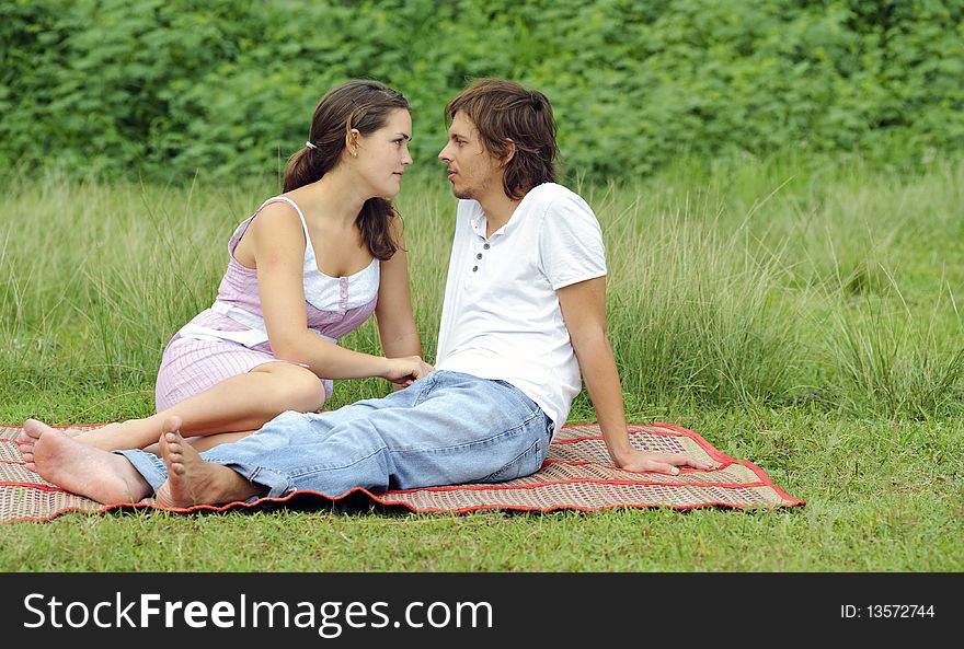 Young couple in love sit together in the park. Young couple in love sit together in the park