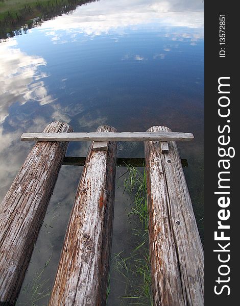 Reflection of sky with Clouds and Floating Raft made of Logs. Reflection of sky with Clouds and Floating Raft made of Logs