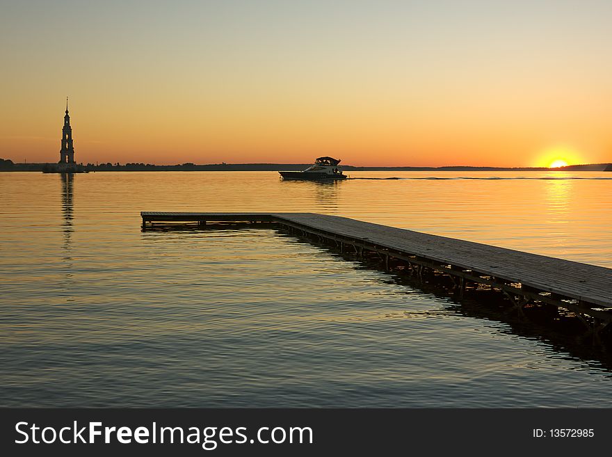 Sunset over Volga river, wooden quay at foreground and boat. Sunset over Volga river, wooden quay at foreground and boat