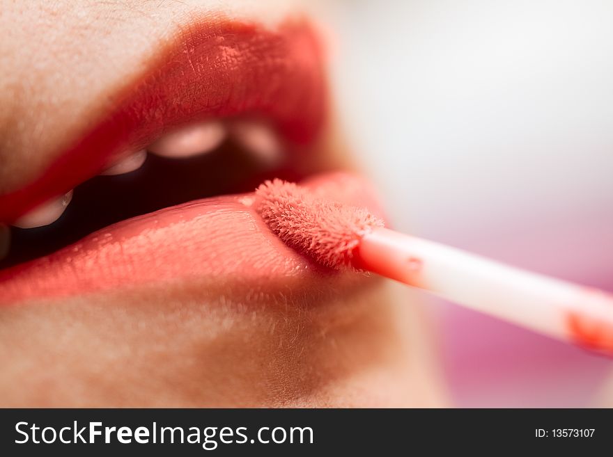 Close-up of a woman lips applying red lipstick. Close-up of a woman lips applying red lipstick.