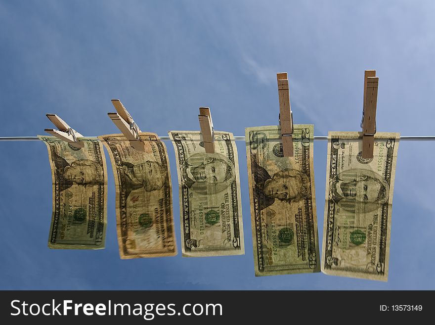 Horizontal picture of money hanging on clothesline against a blue sky. Ample type space. Horizontal picture of money hanging on clothesline against a blue sky. Ample type space.