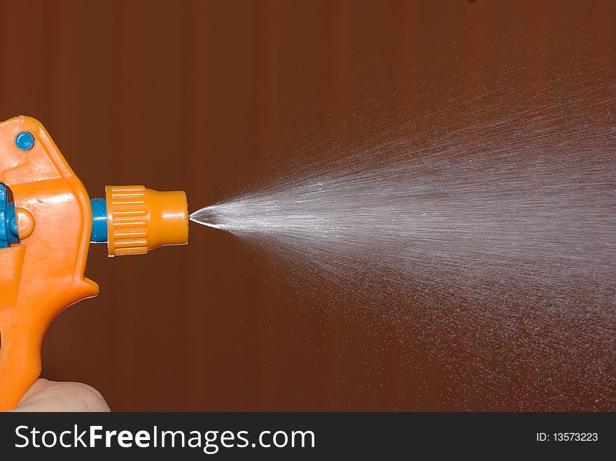 An orange sprinkling water sprayer. An orange sprinkling water sprayer
