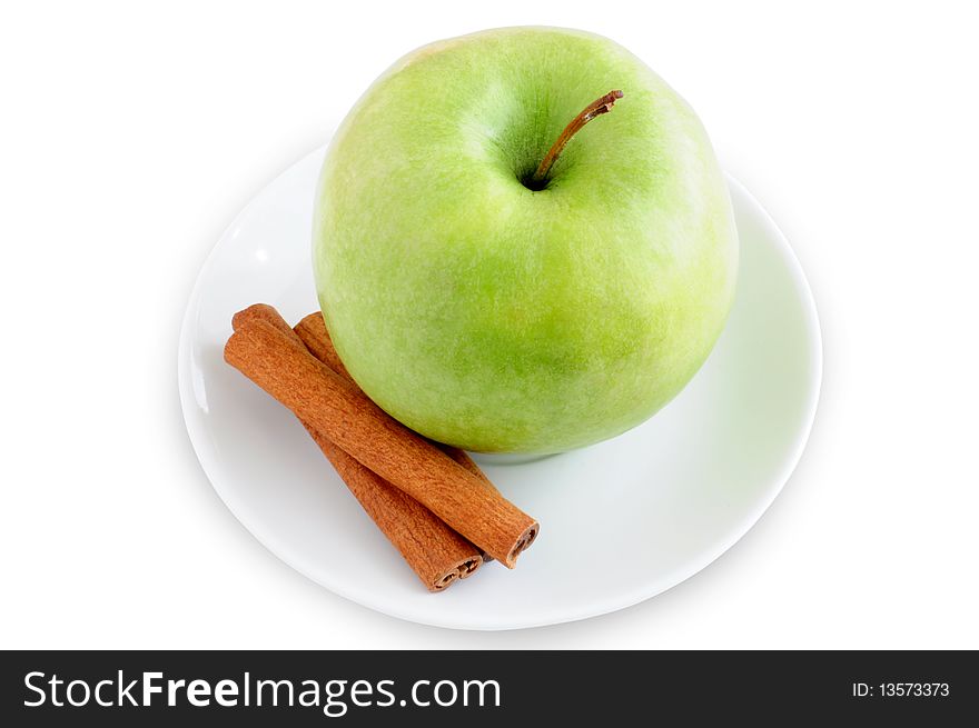 Apple and cinnamon on a plate on a white background