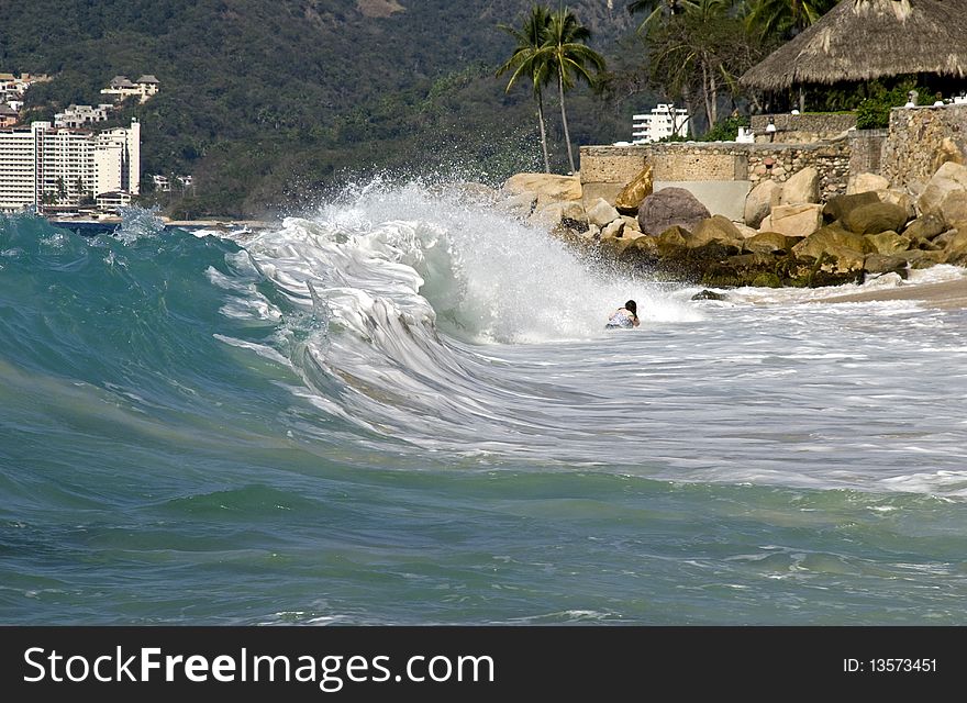 Bather catching high surf on a Puerto Vallarta, Mexico beach
