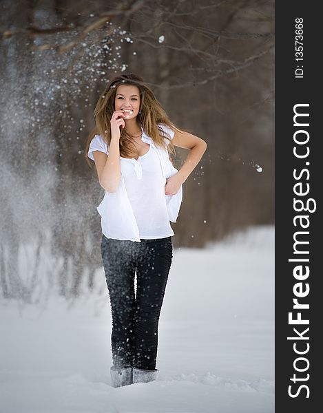 Positive emotion. Fashion model posing in snowdrift in wood