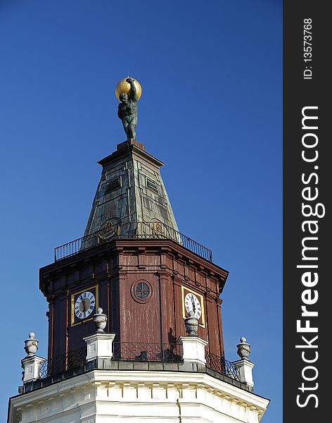 Tower on the town hall with the atlas on the peak into a sunny day