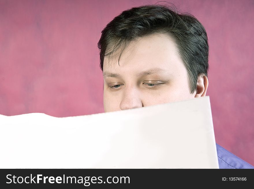 Reading newspaper, studio portrait on pink