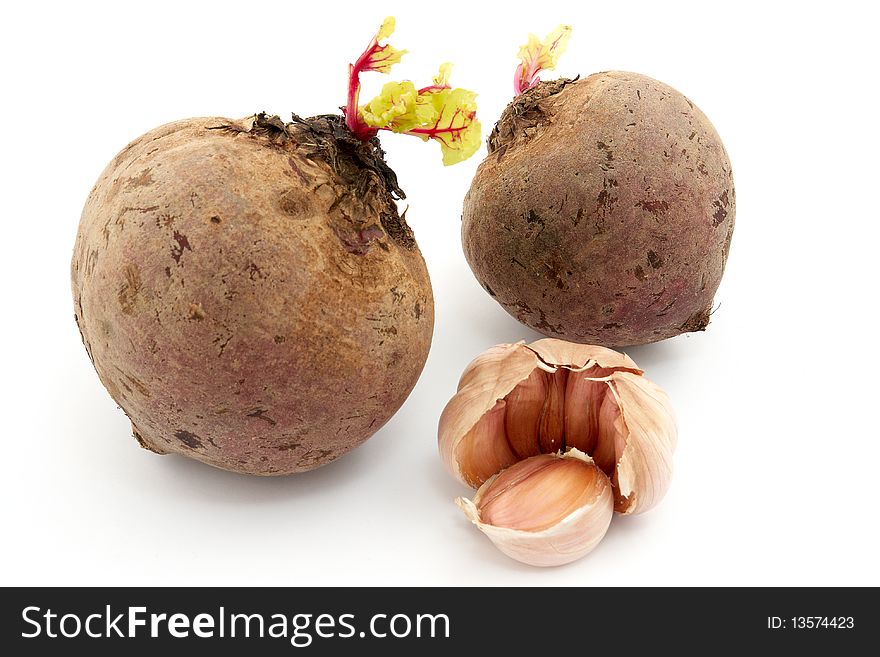 Two beets and garlic with sprouts on white background. Two beets and garlic with sprouts on white background