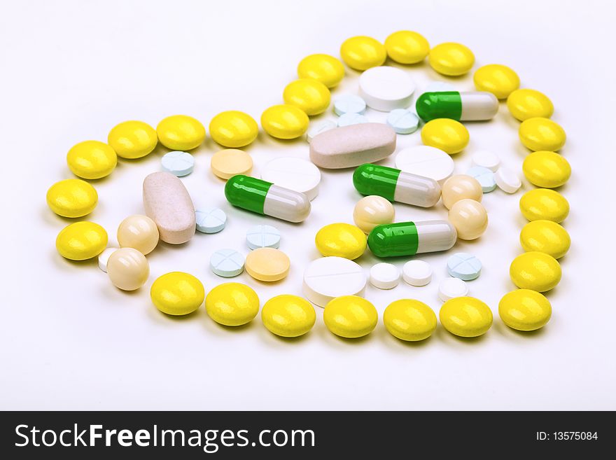 Heart of yellow tablets with  green and white capsule