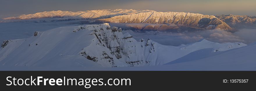 Panoramic Picture with sunrise in Carpathians Mountain, Romania, Bucegi Summit, from Vf.Omu Peak, and Piatra Craiului Mountain far away. Panoramic Picture with sunrise in Carpathians Mountain, Romania, Bucegi Summit, from Vf.Omu Peak, and Piatra Craiului Mountain far away.