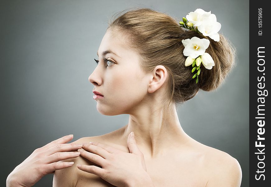 Portrait of beautiful girl with white freesia on grey background. Portrait of beautiful girl with white freesia on grey background