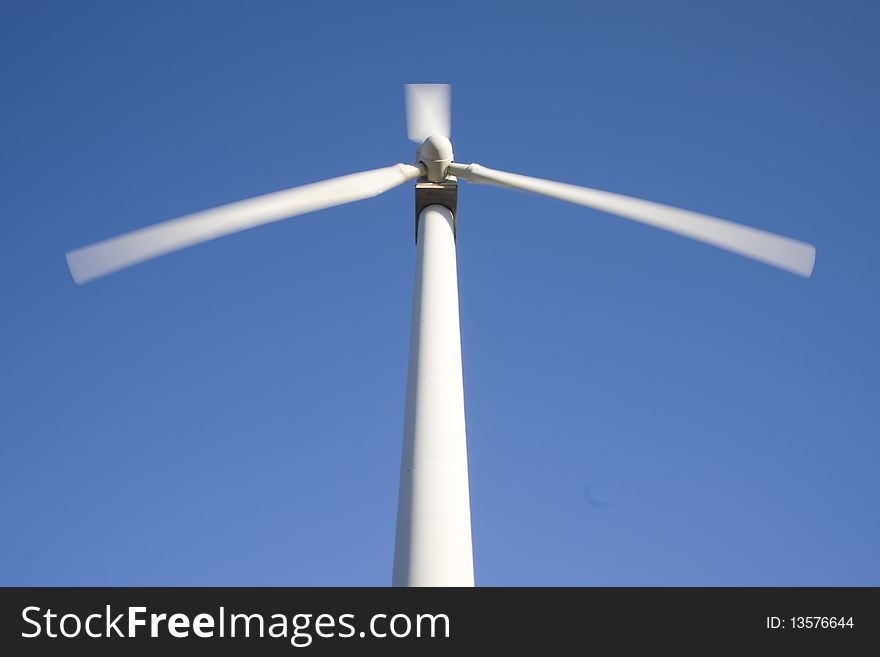 Wind turbine isolated over a blue sky. Alternative energy source