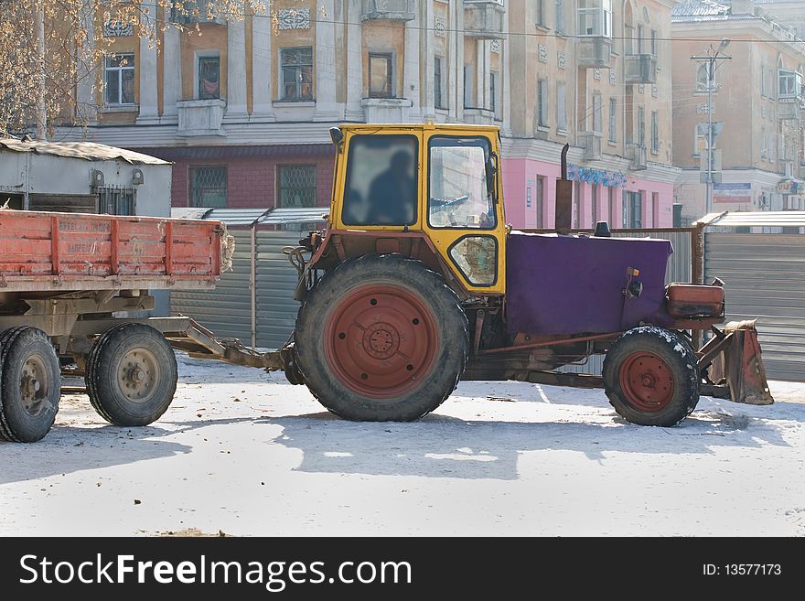 The heavy building bulldozer working on snow