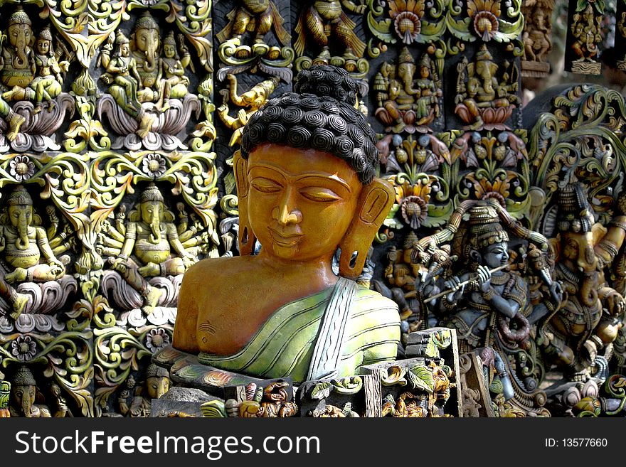 A sculpture of buddha against a background full of idols