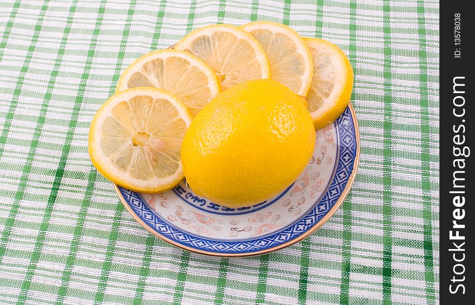Fragrant tasty useful lemon cup with blue figure on napkin green strip. Fragrant tasty useful lemon cup with blue figure on napkin green strip