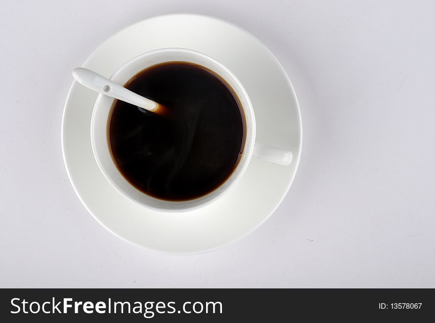 Top view of a cup of coffee, with a spoon beside, means drinking, rest and relax. Top view of a cup of coffee, with a spoon beside, means drinking, rest and relax.