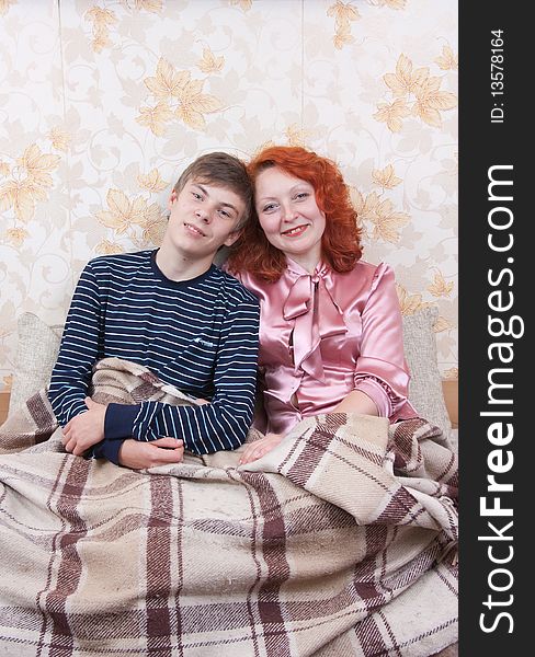 Son with mother sitting on sofa and smiling. Son with mother sitting on sofa and smiling