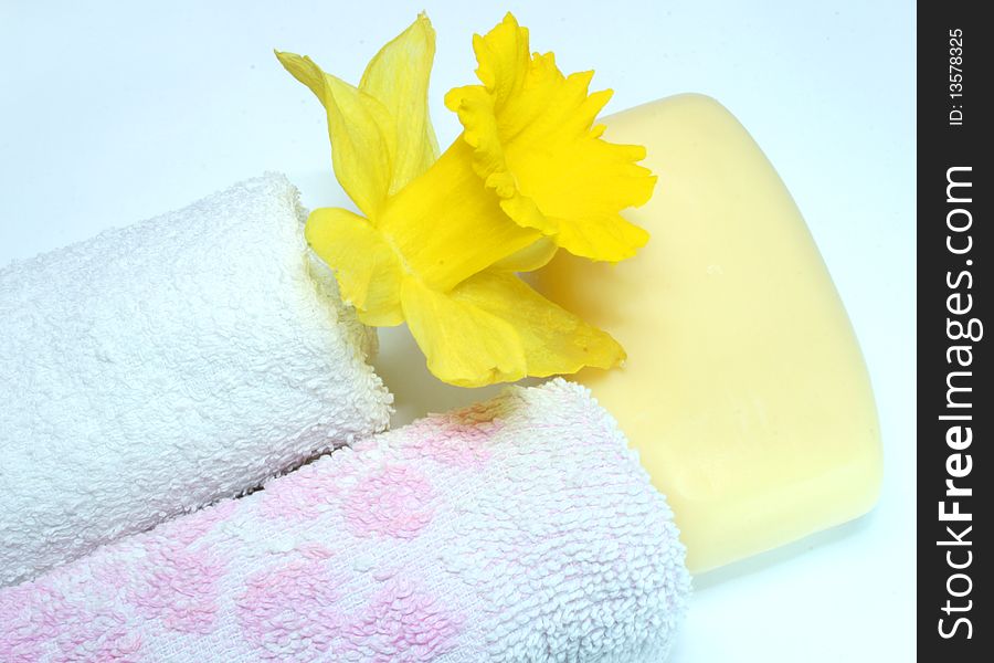 Two towels, soap and yellow flower at the white background. Two towels, soap and yellow flower at the white background