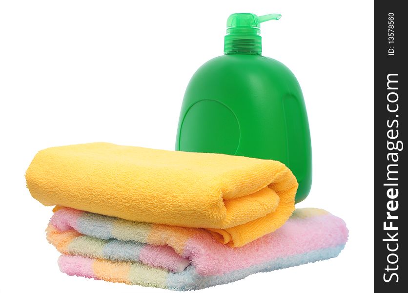 Green plastic bottle and two colour towels on white background. Green plastic bottle and two colour towels on white background.