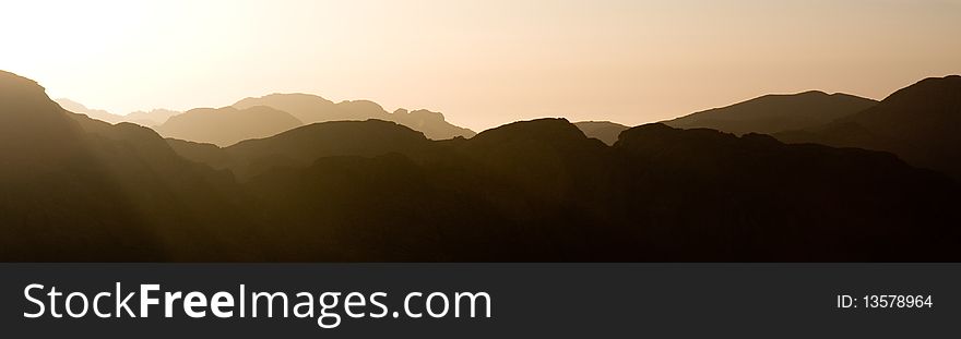 Panorama of the sun setting over misty mountains. Panorama of the sun setting over misty mountains