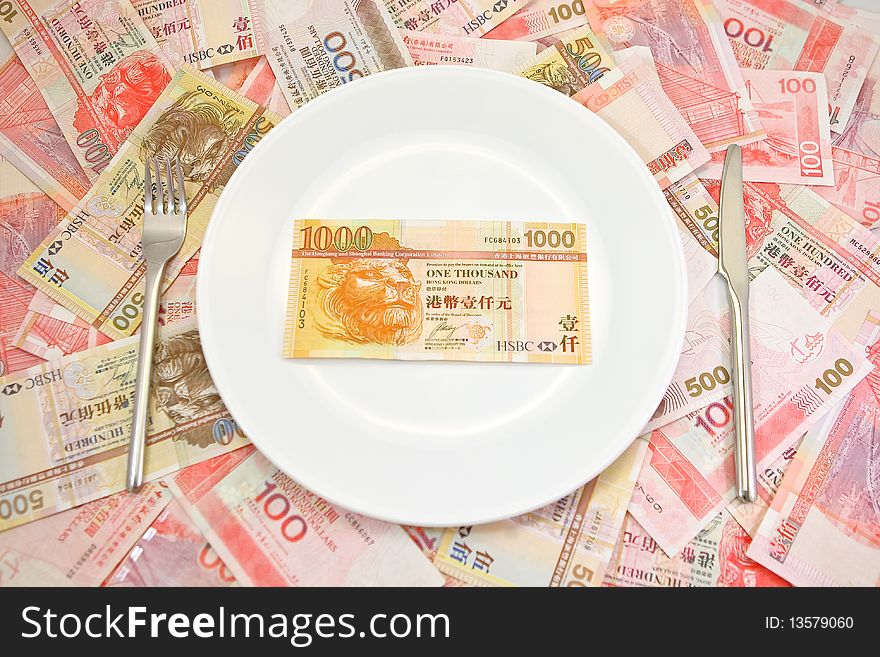 Hong Kong $1000 dollar bill served on a plate on a pile of $100 and $500 Hong Kong dollar bills. Hong Kong $1000 dollar bill served on a plate on a pile of $100 and $500 Hong Kong dollar bills.