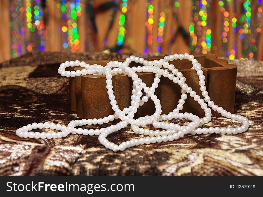 White pearl necklace in a box on an abstract background