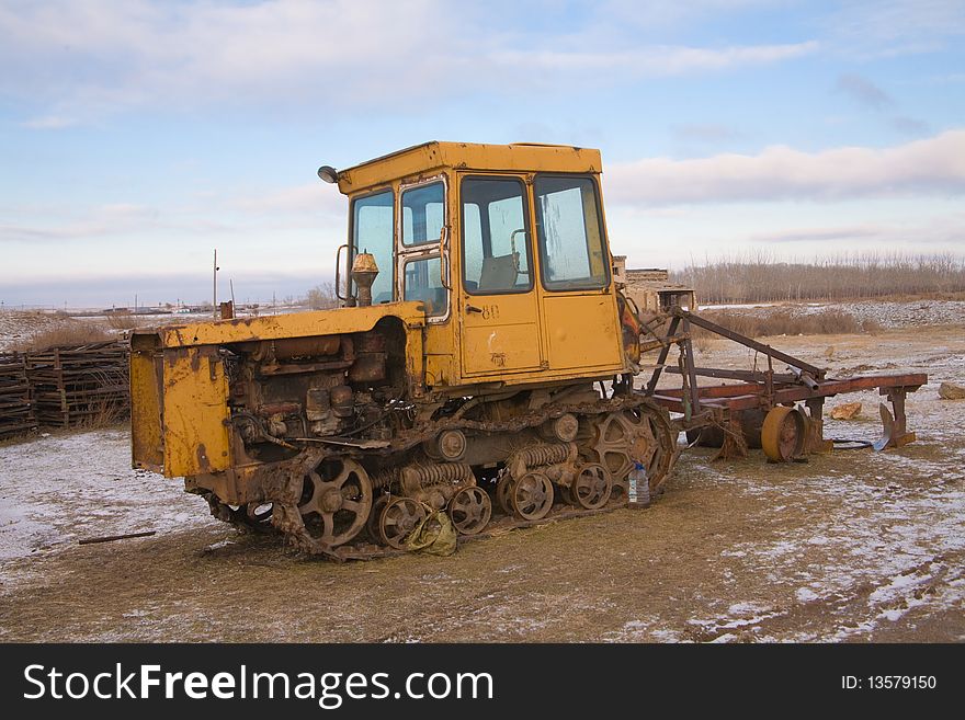 The yellow heavy building bulldozer, tractor in field. The yellow heavy building bulldozer, tractor in field