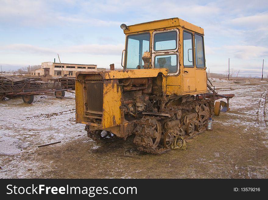 The yellow heavy building bulldozer,tractor in field. The yellow heavy building bulldozer,tractor in field